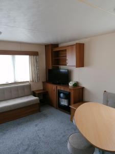 a living room with a couch and a table at Yare Village, Breydon water holiday park in Great Yarmouth