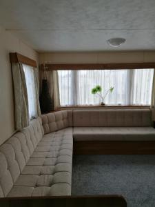a large couch in a room with a window at Yare Village, Breydon water holiday park in Great Yarmouth