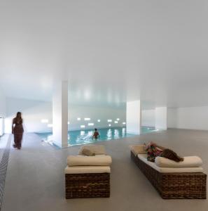 ECORKHOTEL Evora في ايفورا: شخص يستلقي على أريكة في غرفة مع مسبح