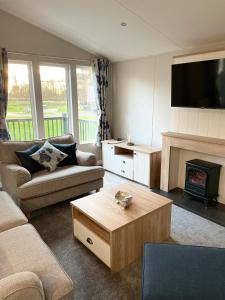 a living room with a couch and a fire place at Beryl Lodge with Hot Tub in York