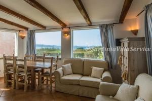 un soggiorno con un divano, un tavolo e delle sedie di Villa Cala Granu - Porto Cervo a Porto Cervo