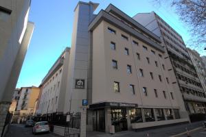 Un alto edificio bianco in una strada di città di Hotel Domenichino a Milano