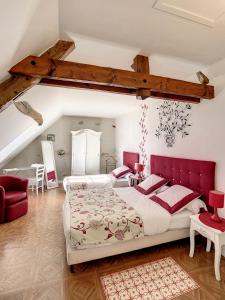 a bedroom with two beds and a red headboard at Chambres d'Hôtes L'Orée des Vignes in Saint-Père