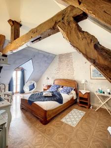 - une chambre mansardée avec un grand lit dans l'établissement Chambres d'Hôtes L'Orée des Vignes, à Saint-Père