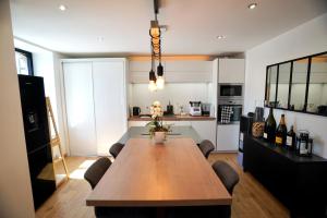 cocina con mesa de madera y comedor en Maison Haut de Gamme à 5min à pied de la Cathédrale de Quimper, en Quimper