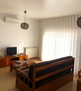 een woonkamer met een bank en een salontafel bij Alojamentos Campo & Mar - T1 com Piscina in São Martinho do Porto