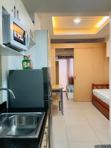 a kitchen with a sink and a bed in a room at Wind Suites Tagaytay at SMDC in Tagaytay