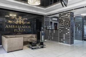 a luxury lobby with a couch and a sign on the wall at Ambassador Plaza in Kyiv