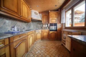 una cucina con armadi in legno e pavimento piastrellato di Apartment Clair Joie Rez a Verbier