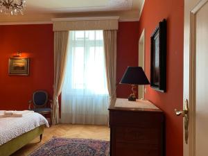 a bedroom with red walls and a bed and a window at dolce vita in Biasca