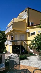 ein großes gelbes Gebäude mit Balkon davor in der Unterkunft Villa Manja in Pirovac