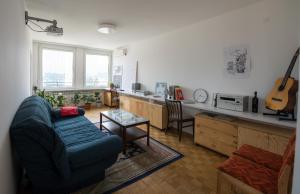 ein Wohnzimmer mit einem blauen Sofa und einem Tisch in der Unterkunft UNIT4SIX in Sarajevo