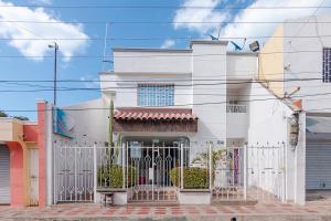 uma casa branca com um portão na frente em Casa Hotel Jimatta em Ríohacha
