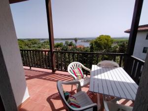 balkon ze stołem i krzesłami oraz widokiem na ocean w obiekcie La Casa Bianca - Alghero Calich w mieście Alghero