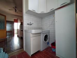 kuchnia z pralką i zlewem w obiekcie La Casa Bianca - Alghero Calich w mieście Alghero