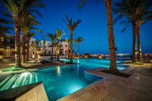 una piscina con palmeras por la noche en El Gouna en Hurghada