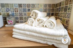 a stack of towels on a counter in a bathroom at L'Haussmann, Rare, Appartement Vue Château et Palmiers in Pau +20 photos