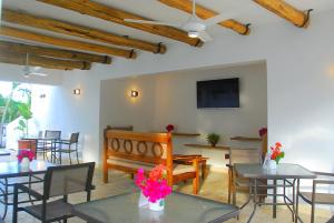 une salle à manger avec des tables, des chaises et une télévision dans l'établissement Nuovo Hotel Playa Catalina, à La Romana