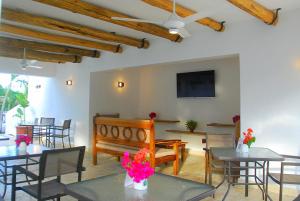 a dining room with tables and chairs and a tv at Nuovo Hotel Playa Catalina in La Romana