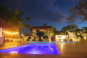a swimming pool in front of a house at night at Nuovo Hotel Playa Catalina in La Romana