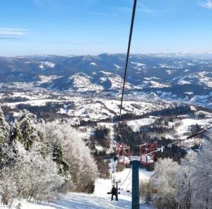 wyciąg narciarski zmierzający w górę pokrytą śniegiem w obiekcie Шале Карпатська Казка w Sławsku