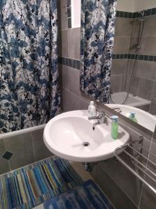 y baño con lavabo, espejo y bañera. en Giramondo Sardegna Affittacamere, en Alghero