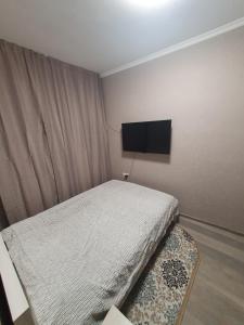a small bedroom with a bed and a flat screen tv at Гостевой дом на Цюрупы 32,Г2 in Sochi