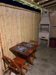 a wooden table with two glasses and a stove at Chalé Casal Perto Praia LAGOINHA - Wi-Fi e Ar-Condicionado - Vila Santa Barbara in Ubatuba +17 photos