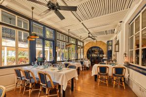 a dining room with tables and chairs and windows at Hotel Trias in Palamós