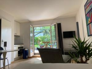 a living room with a table and a kitchen with a window at Furnished studio with garden Seefeld I Tiefenbrunnen in Zurich