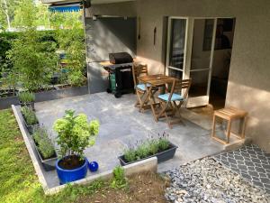 a patio with a table and chairs and plants at Furnished studio with garden Seefeld I Tiefenbrunnen in Zurich