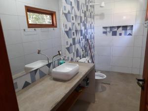 a bathroom with a sink and a toilet at Chalés Cumuruxatiba in Cumuruxatiba