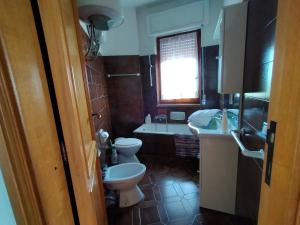 łazienka z dwiema toaletami, wanną i umywalką w obiekcie La Casa Bianca - Alghero Calich w mieście Alghero +9 zdjęć
