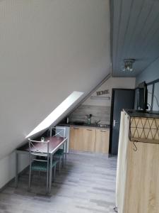 une chambre avec un escalier, une table et une cuisine dans l'établissement CHAMBRE STUDIO avec KICHENETTE SOLEIL DE NACRE, à Hermanville-sur-Mer