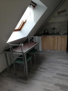 エルマンヴィル・シュル・メールにあるCHAMBRE STUDIO avec KICHENETTE SOLEIL DE NACREの屋根裏にテーブルと椅子付きのキッチン
