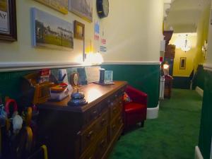 een kamer met een bureau en een rode stoel bij Green View Guest House in Silloth