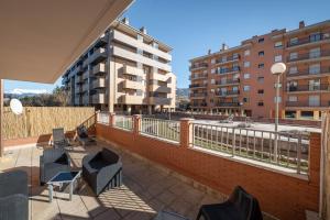 a balcony with chairs and a building in the background at Apartamento en Sabiñánigo con amplia y soleada terraza in Sabiñánigo