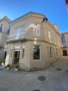 un gran edificio de ladrillo con un balcón en la parte superior. en A Casa dos Nores Charming House en Cangas de Morrazo