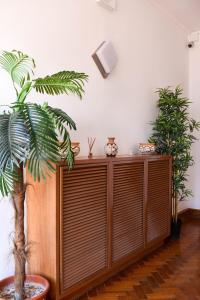 a wooden cabinet in a room with a palm tree at Batalhoz House in Cartaxo