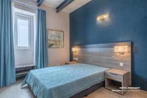 um quarto azul com uma cama e uma janela em No. 31 in Valletta em Valeta