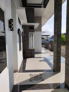 a houserendering of a front porch with a door and columns at Cahaya kos putri in Banda Aceh