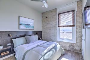 a bedroom with a bed and a brick wall at Sleek, Newly Updated Downtown San Marcos Apt! in San Marcos