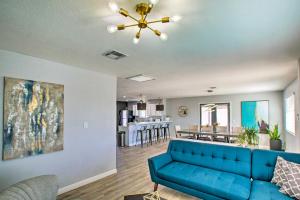 a living room with a blue couch and a kitchen at Charming Phoenix Home with Patio about 3 Miles to Dtwn! in Phoenix