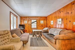 een woonkamer met 2 banken en houten wanden bij Remote Michigan Retreat on 10 Acres with Grill! in Irons
