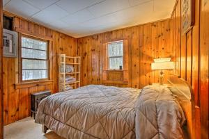 een slaapkamer met houten wanden en een bed in een kamer bij Remote Michigan Retreat on 10 Acres with Grill! in Irons