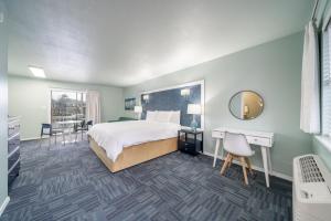 a bedroom with a bed and a desk and a mirror at The Hamilton - Lakefront & Studio Suites, Hot Springs in Hot Springs