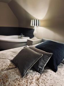 a bed with two pillows and a bath tub in a bedroom at Ring Residenz by E&P Concept in Adenau