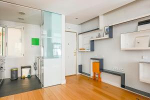 um quarto com uma cozinha com um frigorífico e uma cadeira em Heima Retiro Park-Ibiza em Madri