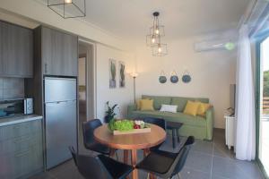 a kitchen and a living room with a table and chairs at Villa Freya - Melisou Villas in Kalamitsi