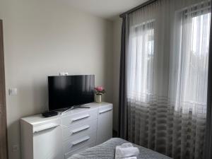 巴拉頓菲賴德的住宿－Sun Resort Luxury Apartman，卧室配有带窗户的梳妆台,提供电视